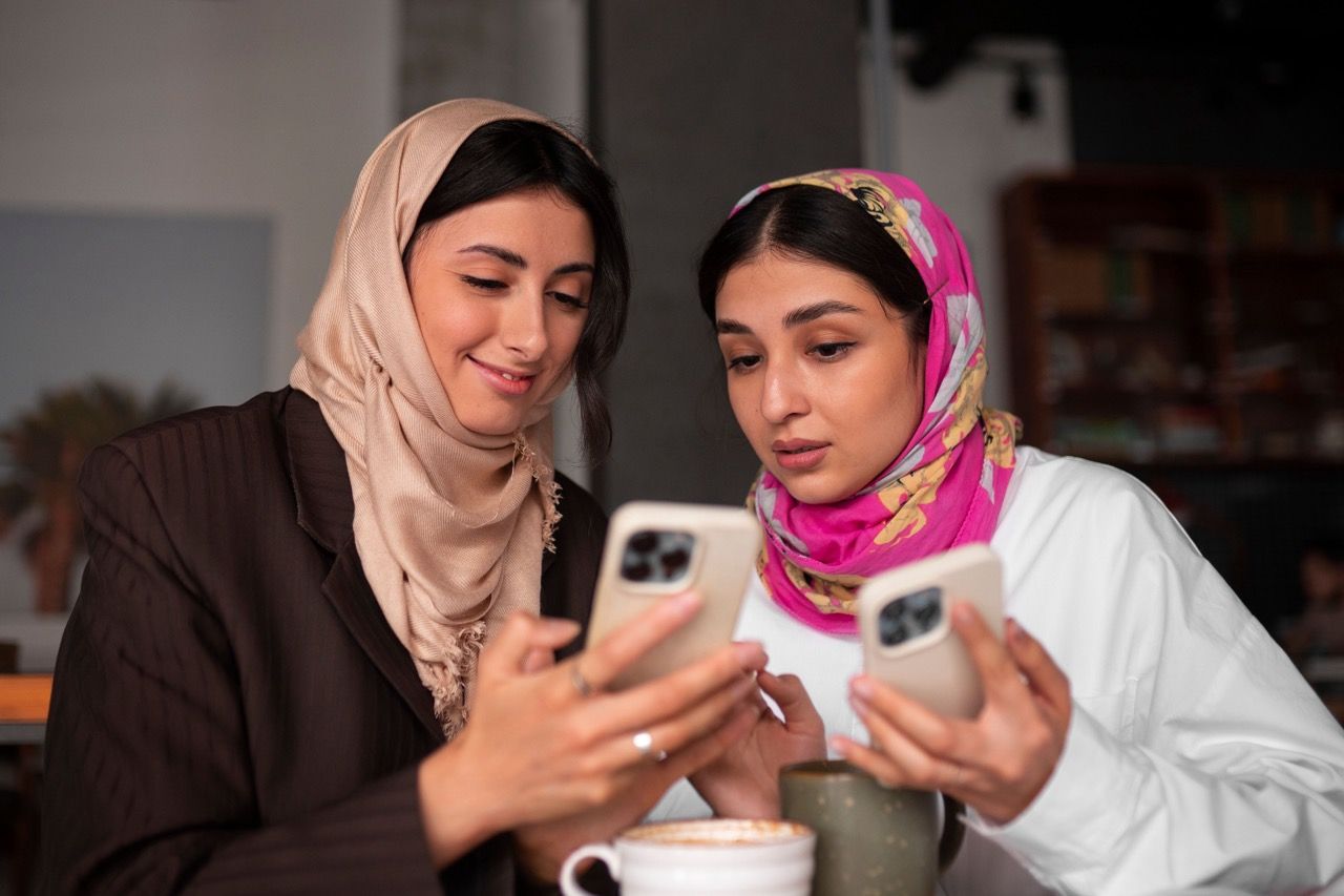 medium_shot_women_holding_smartphones_472d3cb873 Large.jpeg